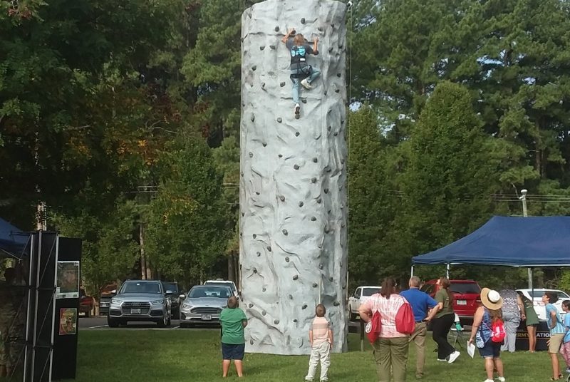 Onlookers watch rock climber at Family & Farm Day