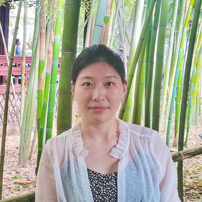 Young woman in front of bamboo stalks