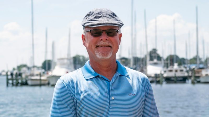 Michael Schwarz stands in front of the Hampton River and a dock