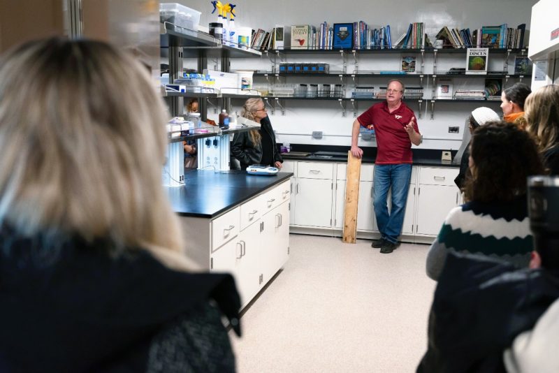 Researcher talking to a group of people in a water chemistry lab