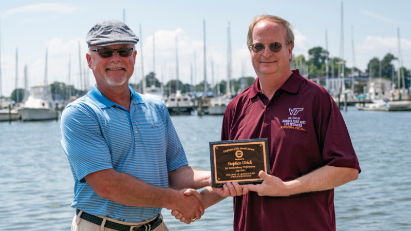 Michael Schwarz presents Steve Urick with CALS employee of the month award.