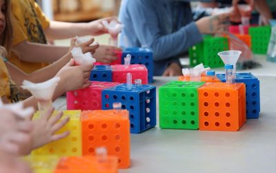 Children with colorful blocks and test tubes doing science experiments.