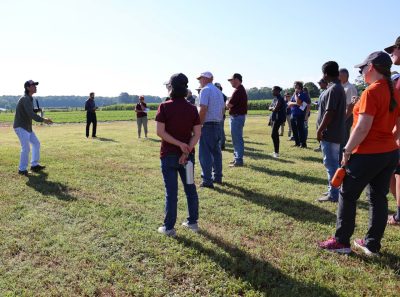 Attendees listen to presentation in the field at Tidewater AREC during the Precision Ag Technology Expo