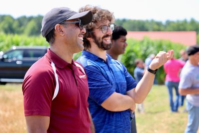 Two men smiling and discussing a field demo at the Precision Ag Expo
