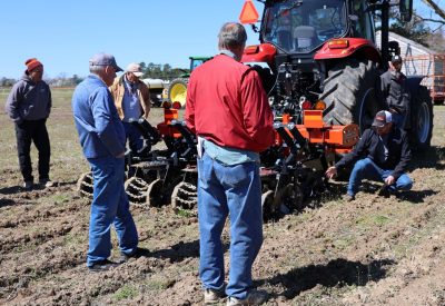 A group of men look on during an equipment demo during cover crop field day