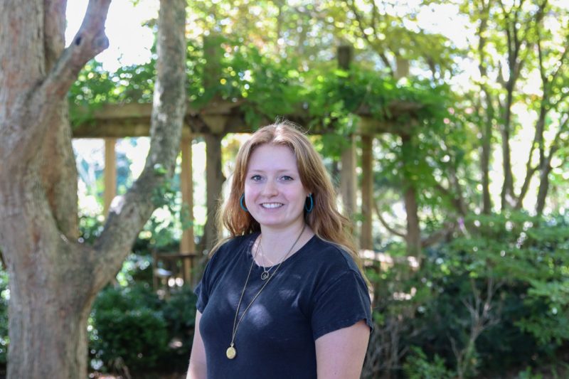 Young woman outside with trees in background