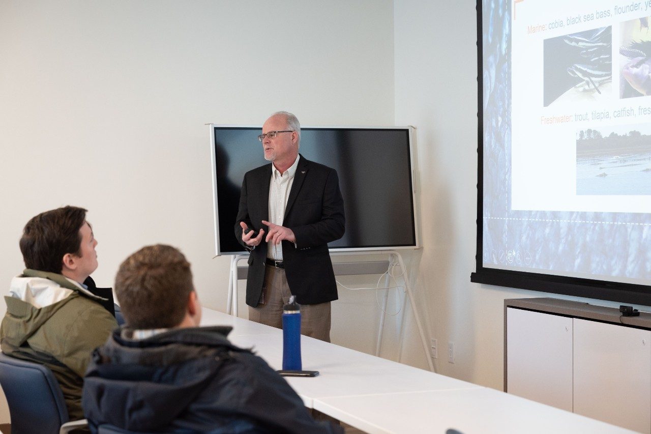 Faculty member speaking to group of listeners