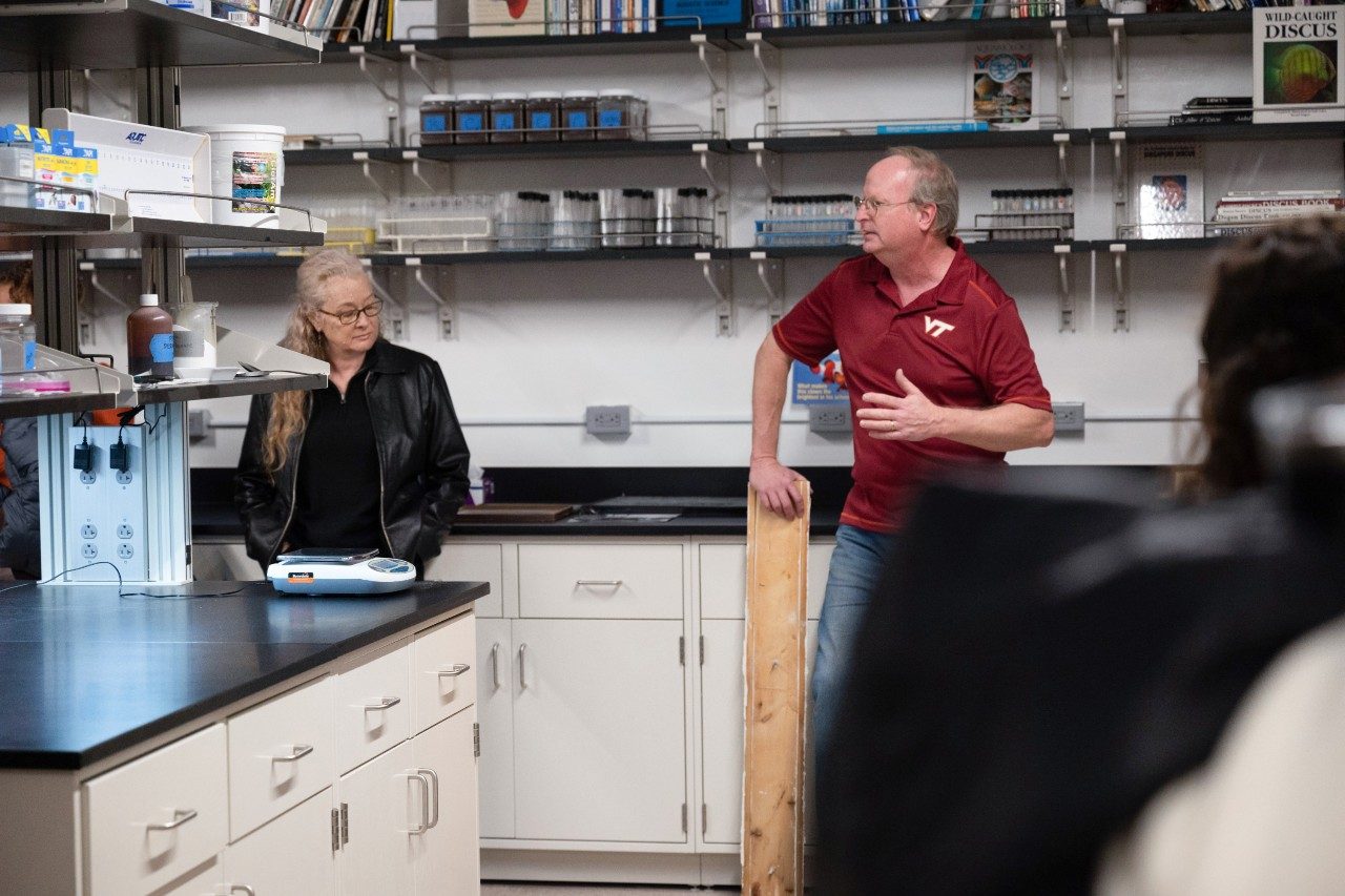 Researcher talking to a group of people in a water chemistry lab