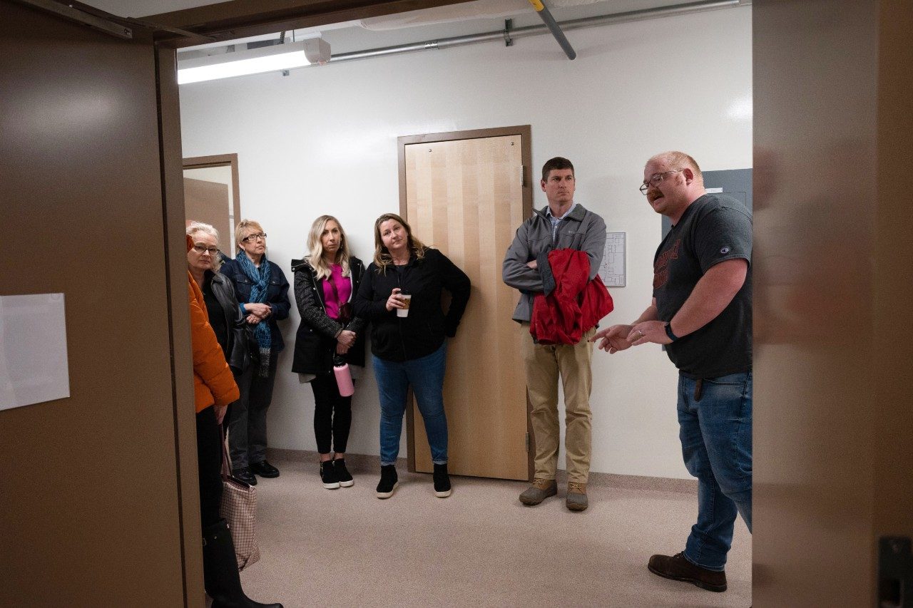 Researcher guiding visitors through hallway